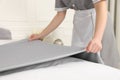 Maid making bed in hotel room, closeup Royalty Free Stock Photo
