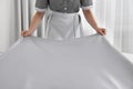 Maid making bed in hotel room, closeup Royalty Free Stock Photo