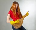 Cheerful housewife playing on her guitar broom. Royalty Free Stock Photo