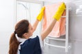 Maid replacing towel on rack in bathroom