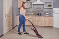 Maid uses wireless vacuum cleaner in the kitchen Royalty Free Stock Photo