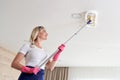 Maid woman holding mop pile, cleaning ceiling in living room. House cleaning service concept. Royalty Free Stock Photo