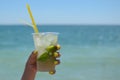 The maiden`s hand holds a transparent glass of ice with lemon and mint. Mojito Royalty Free Stock Photo