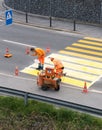 Maienfeld, GR / Switzerland - April 2, 2019: workers painting and marking a pedestrian crosswalk with fresh yellow paint to ensure Royalty Free Stock Photo