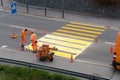 Maienfeld, GR / Switzerland - April 2, 2019: workers painting and marking a pedestrian crosswalk with fresh yellow paint to ensure Royalty Free Stock Photo