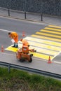 Maienfeld, GR / Switzerland - April 2, 2019: workers painting and marking a pedestrian crosswalk with fresh yellow paint to ensure Royalty Free Stock Photo