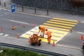 Maienfeld, GR / Switzerland - April 2, 2019: workers painting and marking a pedestrian crosswalk with fresh yellow paint to ensure Royalty Free Stock Photo