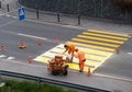 Maienfeld, GR / Switzerland - April 2, 2019: workers painting and marking a pedestrian crosswalk with fresh yellow paint to ensure Royalty Free Stock Photo