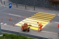 Maienfeld, GR / Switzerland - April 2, 2019: workers painting and marking a pedestrian crosswalk with fresh yellow paint to ensure Royalty Free Stock Photo