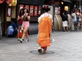 Maiko apprentice geisha or geiko performing artists walking on Hanamikoji Street of Gion old town with Japanese people and foreign Royalty Free Stock Photo