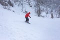 Winter cloudy day, winter sports lovers are engaged in their favorite hobby of conquering the slopes on the mountain slope in the