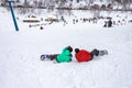 Winter cloudy day, winter sports lovers are engaged in their favorite hobby of conquering the slopes on the mountain slope in the