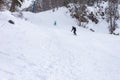 Winter cloudy day, winter sports lovers are engaged in their favorite hobby of conquering the slopes on the mountain slope in the