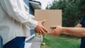 Mailman Delivering a Parcel to an Addressee. Close Up on Hands of a Delivery Service Postman Giving