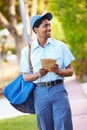 Mailman Walking Along Street Delivering Letters Royalty Free Stock Photo