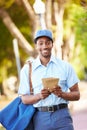 Mailman Walking Along Street Delivering Letters Royalty Free Stock Photo