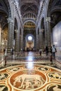 Main aisle and altar from the interior of the Siena Dome Duomo with few visitors during the day