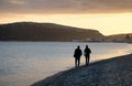 The main beach of Cagliari poetto sella del diavolo with two walking lovers at sunset - Sardinia Royalty Free Stock Photo