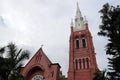 Main building of church and church tower with the tree on sky background at cathedral of the holy trinity. Royalty Free Stock Photo