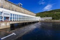 The main building with turbines of the Zeya hydroelectric station on the background of a concrete dam.