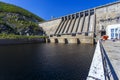 The main building with turbines of the Zeya hydroelectric station on the background of a concrete dam.