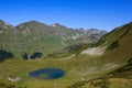 Main Caucasian Ridge and mountain lake surrounded with alpine meadows