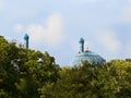 Main dome and minaret of Saint Petersburg Mosque behind the trees on a background blue sky