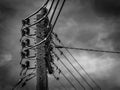 Main electric pole against blue sky with clouds, black and white style