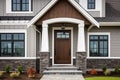 Main entrance door in house. Wooden front door with gabled porch and landing. Exterior of georgian style home cottage with columns Royalty Free Stock Photo