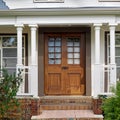 Main entrance door in house. Wooden front door with gabled porch and landing. Exterior of georgian style home cottage with white Royalty Free Stock Photo