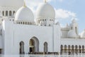 Main entrance with line of tourists of Sheikh Zayed Grand Mosque with blue sky in the morning at Abu Dhabi, UAE