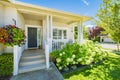 Main entrance of residential house with blossoming flowers in front