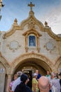 The main entrance to the Milk Grotto Church in Bethlehem in Palestine and people waiting in line.