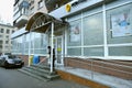 Main entrance to the postal office of the state enterprise Ukrposhta, an old woman client leaving it. Kyiv, Ukraine