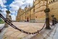 Main facade of the new cathedral of Salamanca with its stone posts and iron chain that surround the monument. Royalty Free Stock Photo
