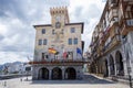 main facade of the town hall of Castrourdiales, with the flags waving in the wind, with its empty square of people, and Royalty Free Stock Photo