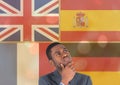 main language flags overlap with gold lights around young man thinking