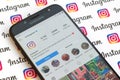 Main official instagram account on smartphone screen on paper instagram banner