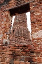 The Main Phra Prang or pagoda, the view through the window of church in the ruins of ancient remains at Wat Worachet temple. Royalty Free Stock Photo