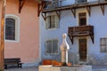 The main square of Ceillac village with a traditional fountain and colorful traditional houses with wooden balconies