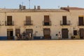 Main square on Island Tabarca with tourist looking for shade for the burning Summer sun