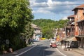 Main street of the center of Barajevo with shops and businesses and a few cars.