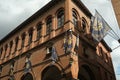 Main street of Foligno with waving flags on the facades of the houses. The ancient palaces lit by the sun with cloudy sky