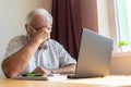 Senior old man male sit desk, home office online notebook laptop work distance freelancer tired unhappy sad sleeping Royalty Free Stock Photo