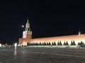 The main tower of the Moscow Kremlin, Russia with huge clock-chimes and a wall of red brick against black night sky and full moon Royalty Free Stock Photo