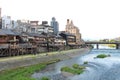 Main view of Kamo river promenade with many terraces of restaurants and bars with Kyoto`s old town buildings on background