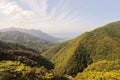 Main view of the northern massive green mountains and seaside of Yakushima Island with city of Miyanoura on background Royalty Free Stock Photo