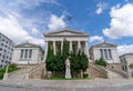 The main white marble facade and impressive double curved stairs of the national library of Athens.