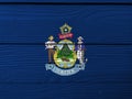 Maine flag color painted on Fiber cement sheet wall background. Maine coat of arms defacing blue field Royalty Free Stock Photo