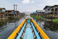 Maing Thauk, Myanmar - April 2019: Traditional Burmese wooden boat going through Maing Thauk village at Inle lake